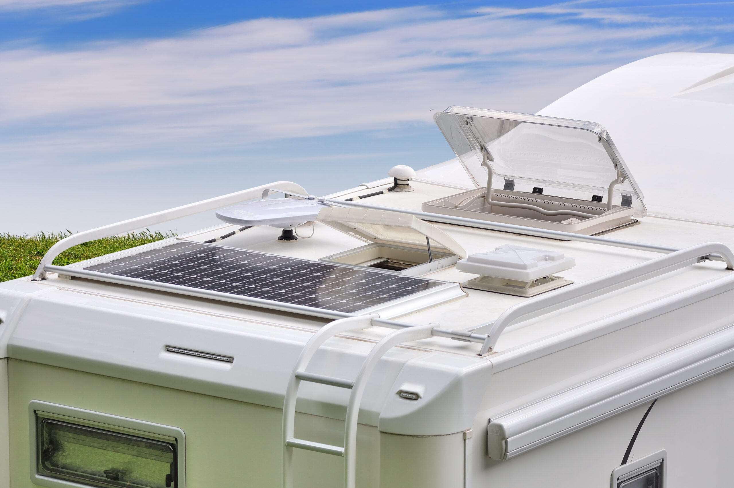 RV roof finished in seamless white polyurea around the vents, ladder and solar panel