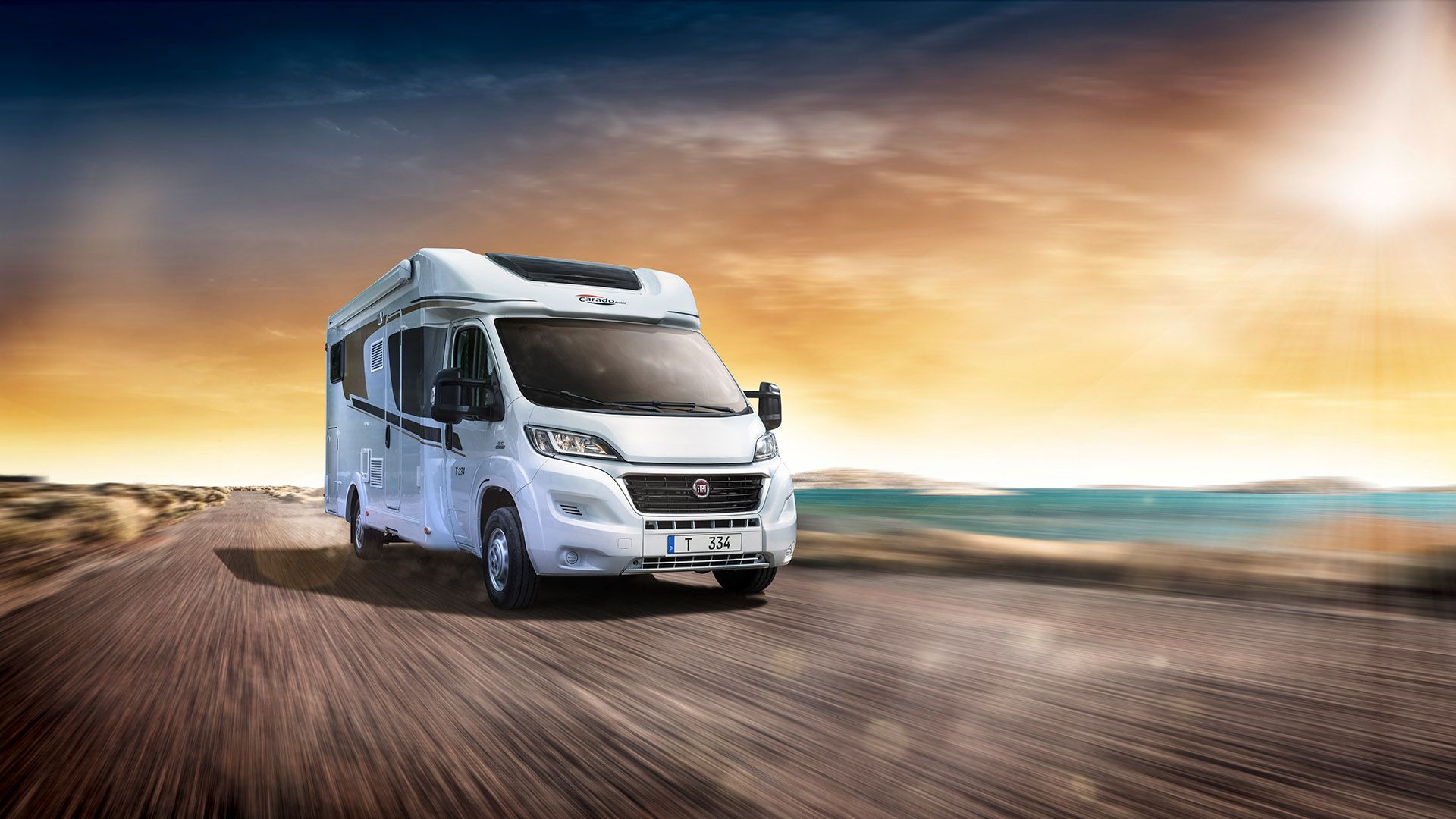 Class C motorhome driving at sunset